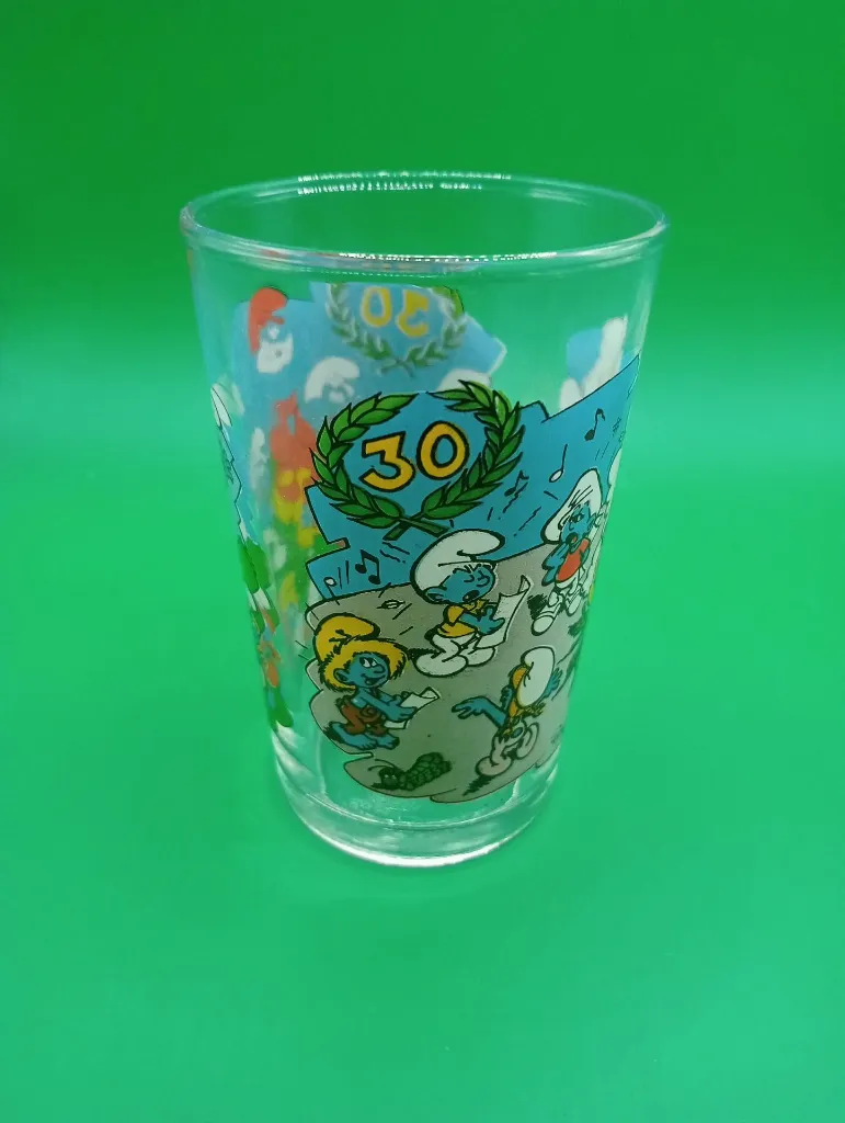 Verre Schtroumpfs 30 ans – © Peyo – IMPS – Schtroumpfs célébrant l’anniversaire autour du grand 30 et couronne de laurier – verre commémoratif