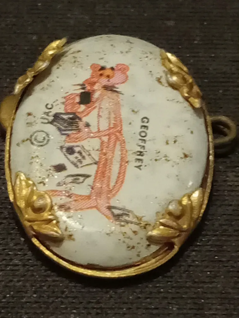 Broche vintage La Panthère Rose – Geoffrey – motif sous résine/émail – cadre métallique doré orné – copyright UAC