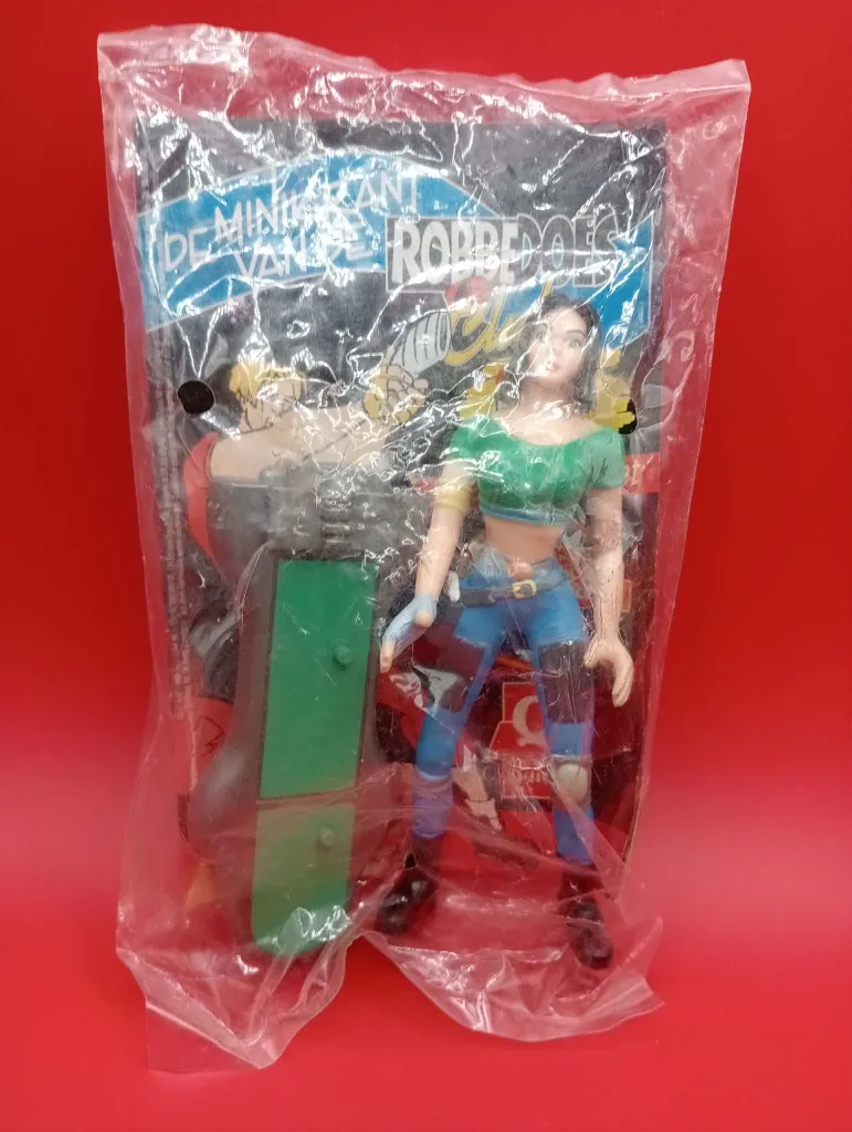 Figurine Dale Arden – Quick – 1998 – Jouet de fast-food sous sachet scellé – vintage – personnage féminin aux cheveux noirs portant un haut vert court et un pantalon bleu avec accessoire de planche de skate gris