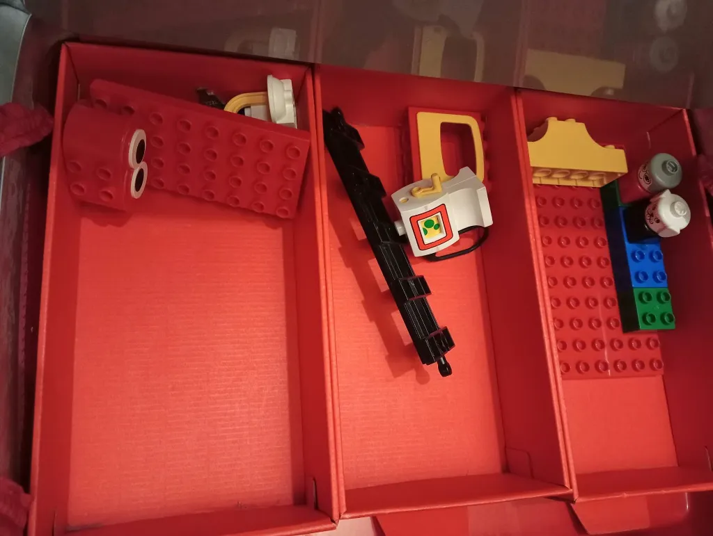 LEGO DUPLO 2770 speelhuis uit 1986 in een rode en zilverkleurige koffer met transparante voorkant, figuren, keuken, badkamer, bedden en meubels