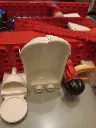 Casa LEGO DUPLO 2770 de 1986 numa mala vermelha e prateada com frente transparente, figuras, cozinha, casa de banho, camas e mobiliário