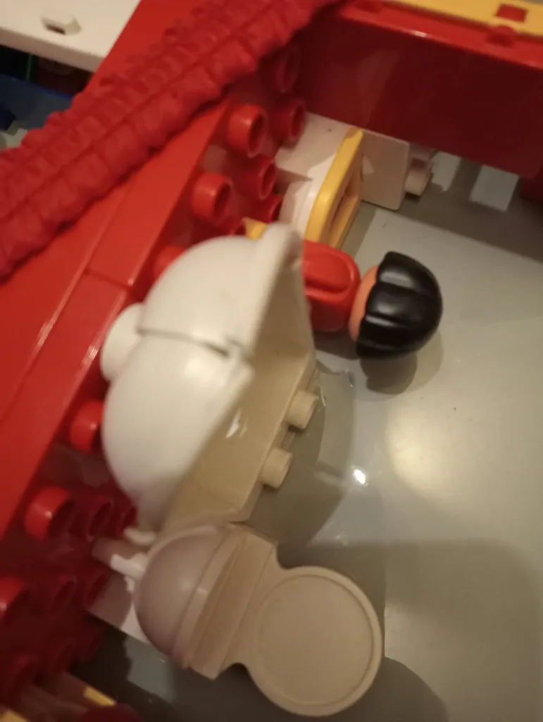 Casa LEGO DUPLO 2770 de 1986 en maleta roja y plateada con frontal transparente, figuras, cocina, baño, camas y muebles