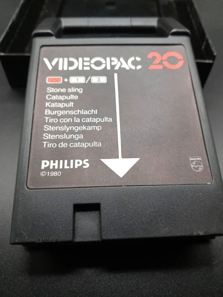 Retrospel Philips Videopac 20 Stone Sling uit 1980 met zwarte cartridge, harde doos met middeleeuwse katapult en originele handleiding