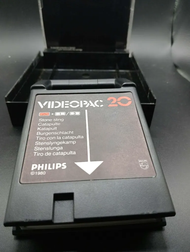 Gioco rétro Philips Videopac 20 Stone Sling del 1980 con cartuccia nera, custodia illustrata con catapulta medievale e manuale originale