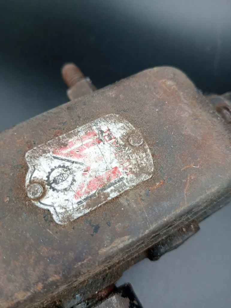 Antique Metabo breast drill in heavily oxidised metal with two-speed gearbox, crank handle, chest plate and worn wooden handles