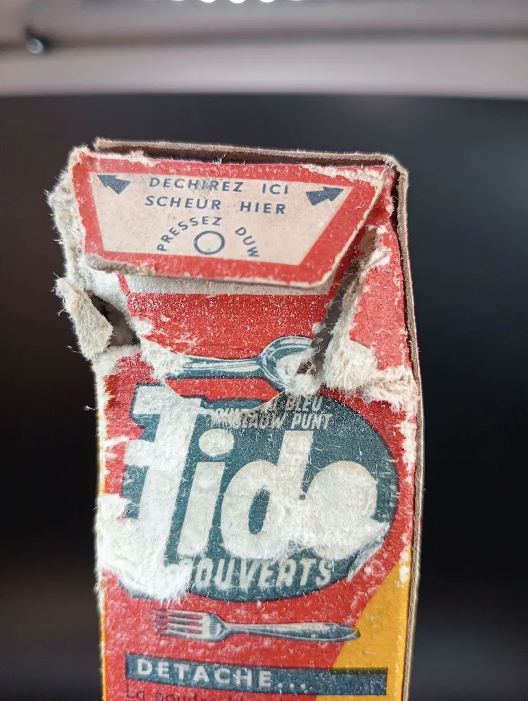 Vintage full bilingual Tide Blue Point detergent box with cutlery promotion, 4.75-franc price, red yellow and blue cardboard and heavily torn upper opening