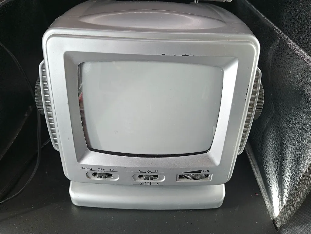 Mini télévision portable argentée TV200 avec écran cathodique noir et blanc de 5,5 pouces, radio AM FM, molettes latérales, antenne télescopique et poignée de transport