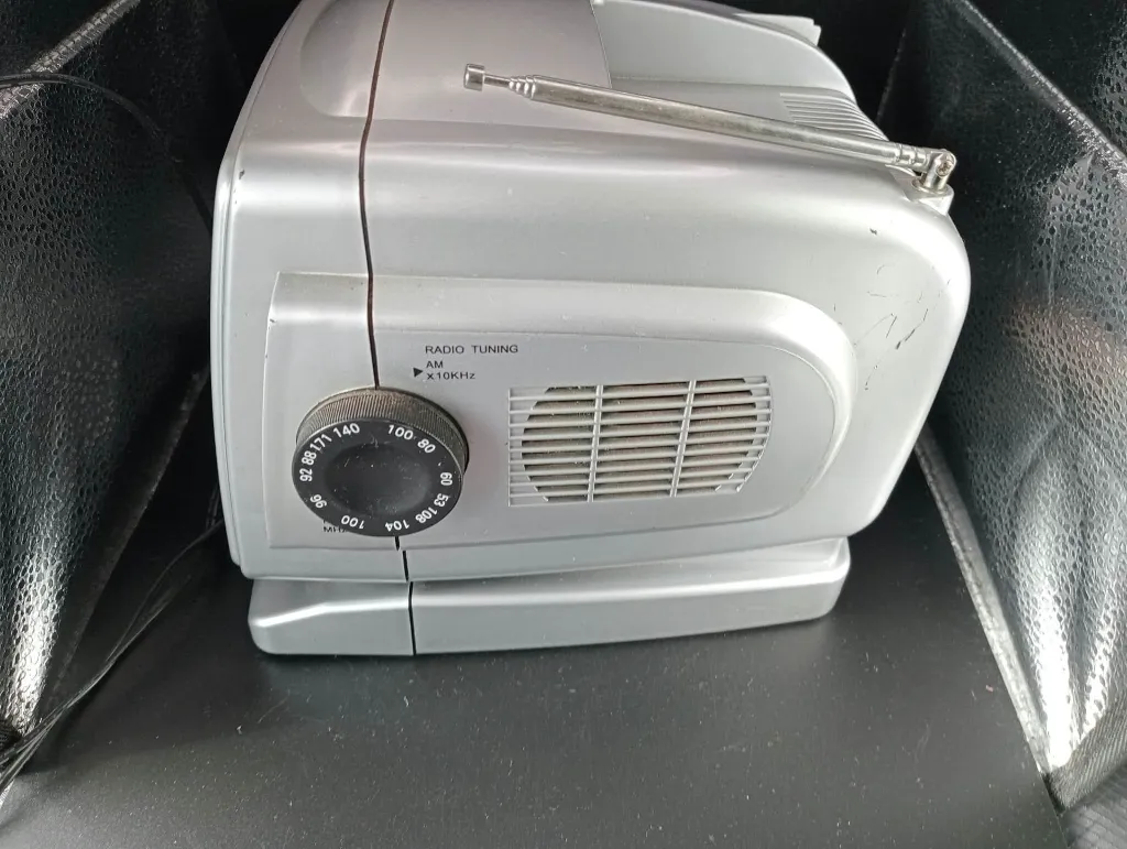 Zilverkleurige draagbare mini-tv TV200 met zwart-wit beeldbuis van 5,5 inch, AM FM-radio, zijdelingse afstemknoppen, telescoopantenne en draaggreep