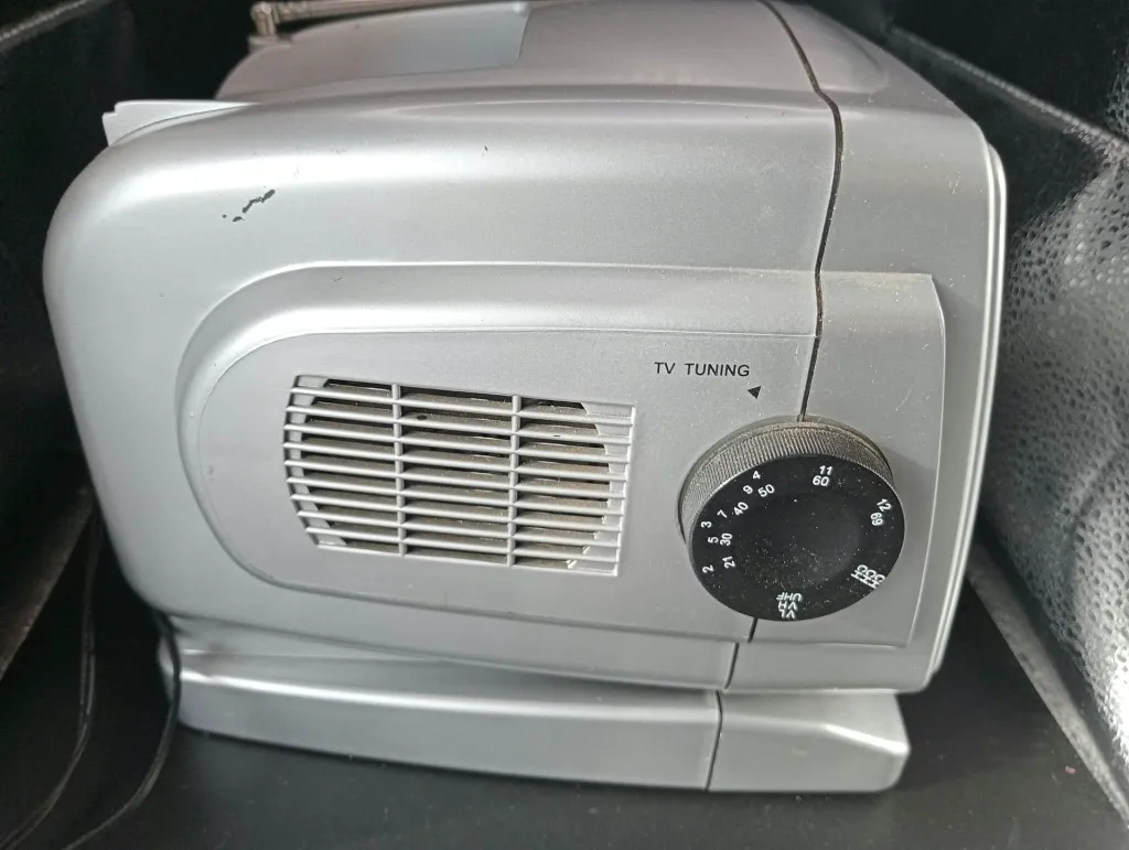 Silver portable TV200 mini television with 5.5-inch black and white CRT screen, AM FM radio, side tuning dials, telescopic antenna and carrying handle