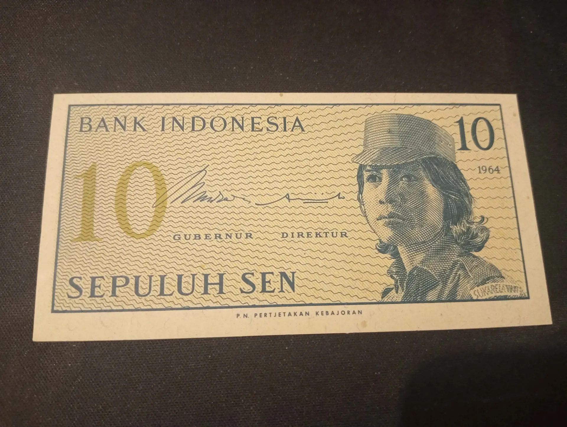 Billete de 10 sen Indonesia 1964 – voluntaria en uniforme & advertencia legal