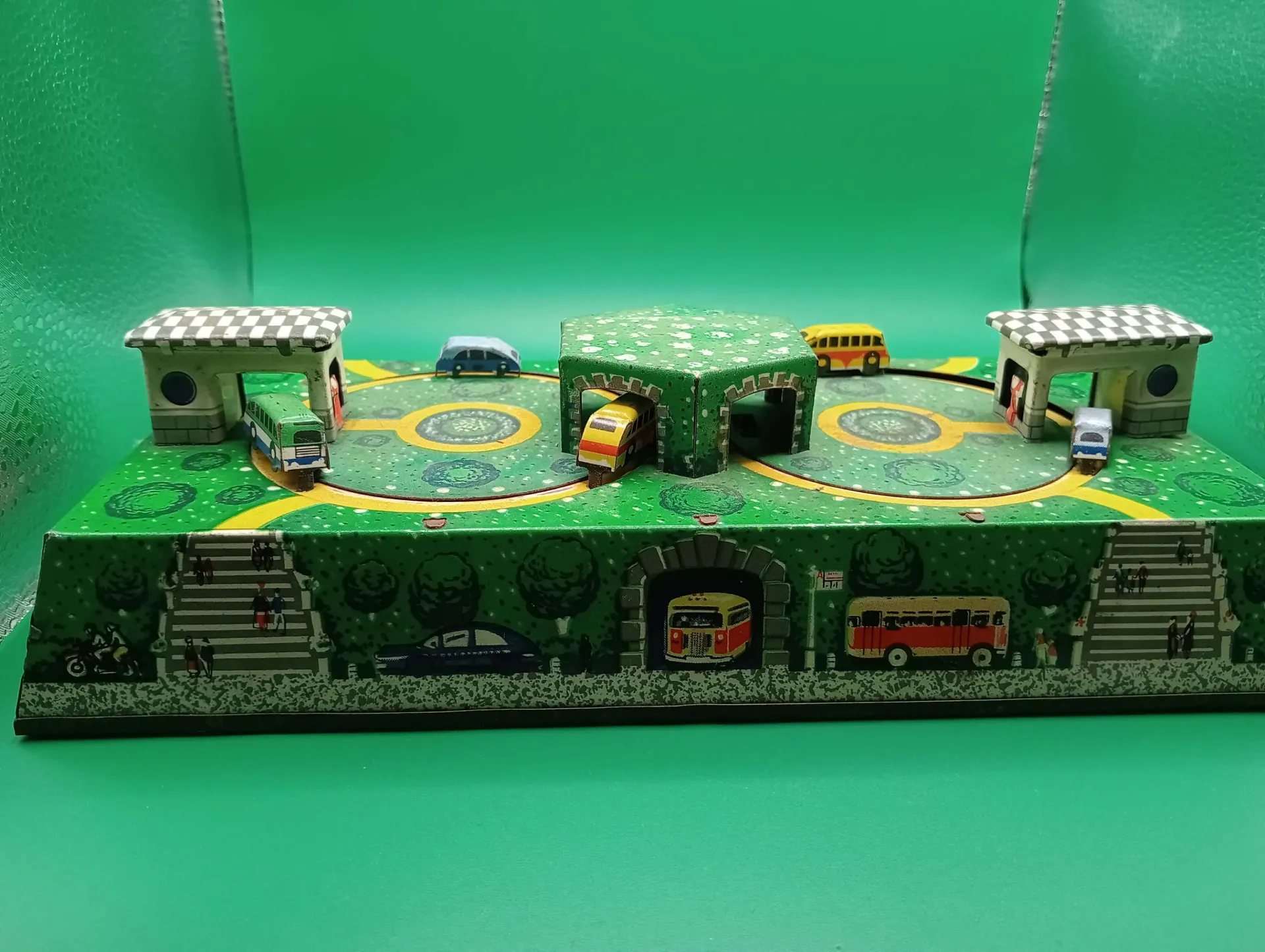 Circuito de coches de hojalata (años 50–60) — monograma W/V, 25×12 cm