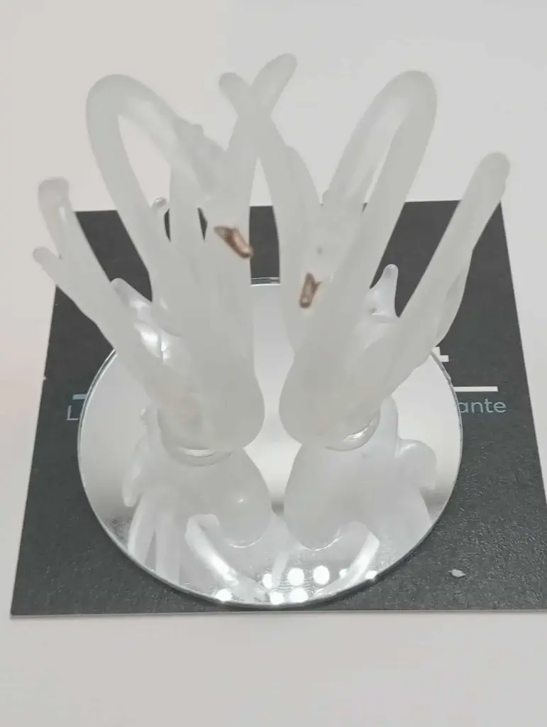 Two frosted glass swans on a mirror