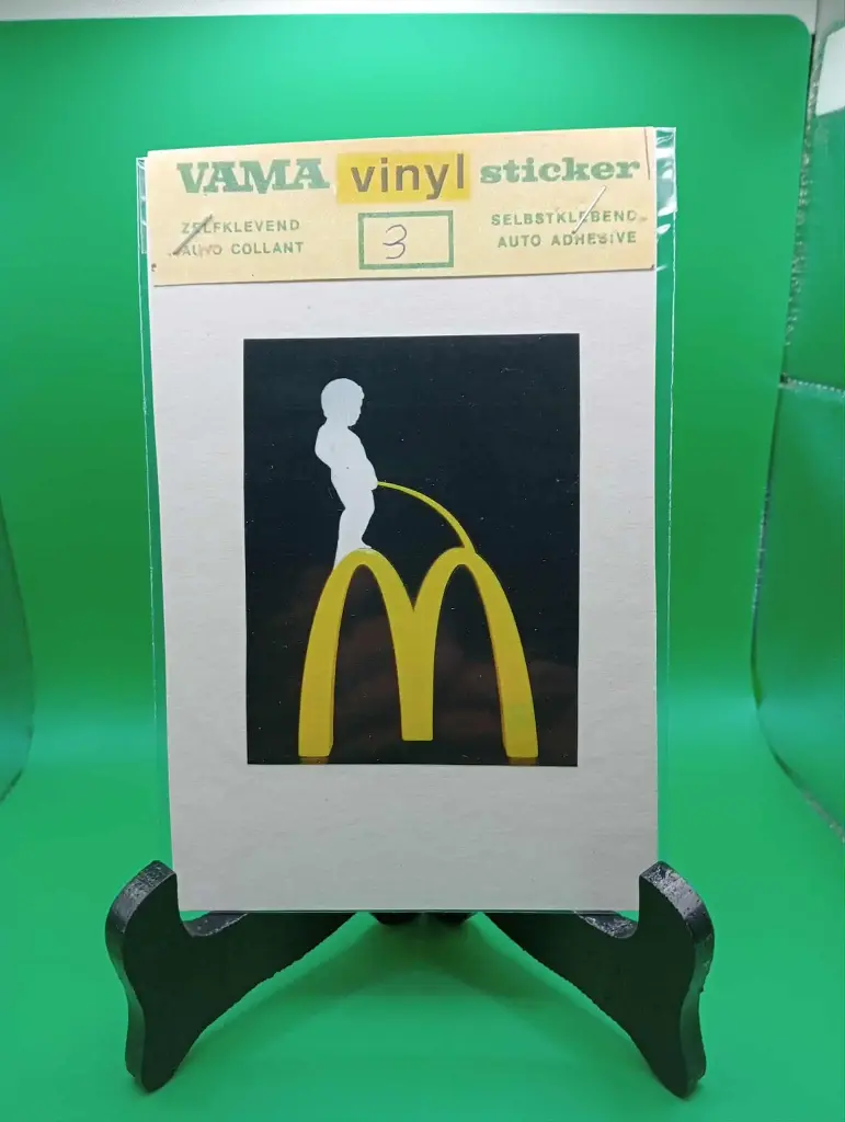 Sticker vintage VAMA – Manneken pis urinant sur logo McDonald’s (années 70, neuf sous blister)