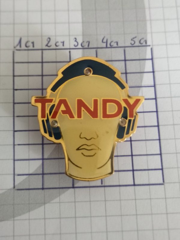 Pin's : Tandy lumineux - visage avec casque audio